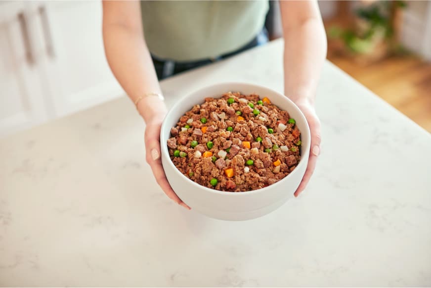 person holding bowl of FreshCooked beef